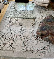 Full view of rug under glass-top coffee table and seating