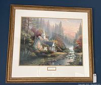 Front view of large framed Thomas Kinkade print titled 'The Forest Chapel' depicting a forest chapel with stream and mountains at sunset.