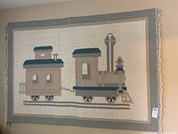 Flat weave rug with a train graphic design hung on a wall.