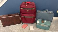 Lot showing all five items together including vintage luggage and two notebooks.