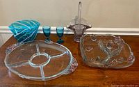 Image showing all glass items on wooden table: robin blue vase, two cordial glasses, clear divided tray, floral serving dish, basket centerpiece