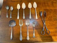 Overview photo of 11-piece vintage silver-plated serveware set displayed on wood surface