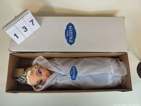 Full boxed Elsa doll wrapped in tissue paper showing Frozen branding on box.