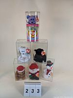 Front view of all six Ty Beanie Babies in clear display cases arranged in a pyramid formation.