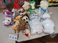 Large assorted lot of various plush stuffed animals including bears, rabbit, panda, giraffe, dinosaur, and Winnie the Pooh figurine.