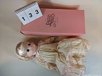 Front view of Jenny doll in dress with original box behind