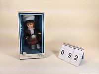 Full view of the doll in original box showing the doll and costume fully visible through window.