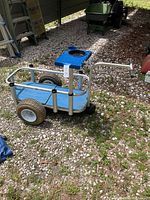 Fishing cart with visible blue aluminum frame, large tires, and work surface with basket and cup holder