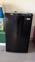 Closed front view of black Magic Chef mini fridge showing its compact size and logo