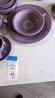 Stack of lilac Fiesta bowl, plate and cup showing concentric ring design.