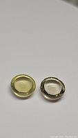 Photo of two round cabochon lemon citrine gemstones, showing smooth domed shape and pale yellow color.