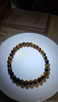 Top view of the natural tigerseye bracelet showing the polished round beads and their characteristic golden brown patterns.