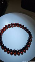 Front view of blood red Baltic amber bracelet showing the deep rich color and round beads