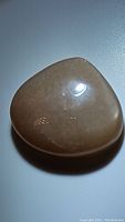 Photo showing polished peach moonstone gemstone with smooth surface and natural shimmer.