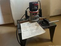 Overall view of Craftsman router mounted on router table with owner's manual on table surface.