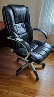 Full view of black padded high back office chair showing overall design and condition.