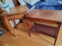 Photo showing two vintage wood side tables positioned on a wood floor, one with drawer and one with lower shelf.