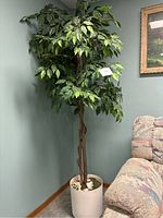 Full view of the faux ficus tree next to a couch showing its size and overall appearance.