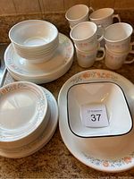 View showing stacked bowls, mugs, various plates all displaying floral pattern and set arrangement on countertop.