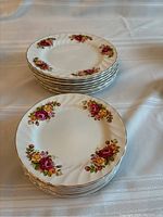 Stack of eight dinner plates and eight lunch plates with Cottage Rose floral pattern and gold trim