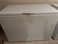 Front view of the white chest freezer with a closed lid, showing its clean and intact exterior.