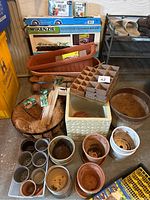 Large assortment of various sized gardening pots, including a chipped square pot, unloaded and stacked. Also includes coco fiber liners, pellet refills, seed strips, and a growth system in original box.