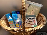 Photo of the woven laundry basket containing iron, starch spray cans, ironing board cover, and other laundry supplies.