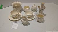 Full view of all Belleek Fine China items showing teacup, saucer, pitcher, vases, and jar