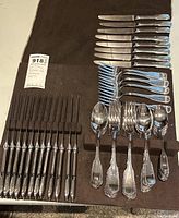 Overview of cutlery arranged on black cloth background showing all groups of utensils