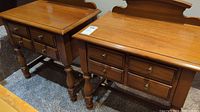 Pair of wooden nightstands side-by-side showing tops, drawers, and legs.
