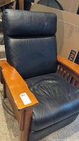 Full view of recliner showing leather upholstery and oak mission style frame