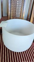 Frosted glass sound bowl shown on chair seat with lot tag.