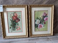 Pair of two framed vintage watercolour floral paintings leaning on floor with labels and tags visible