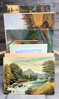 Large box lot of ten original paintings in visible stacked arrangement including framed and unframed items.