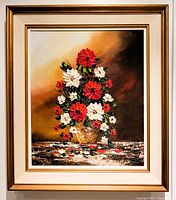 Full view of oil painting in frame showing floral still life with red and white flowers in vase on textured table surface against a warm gradient background.