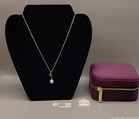Full view of white gold chain displayed on black bust, original product and price tags, and purple velvet zippered storage box.