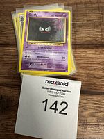 Close-up photo of Gastly Pokemon card on top of stack in protective sleeves.