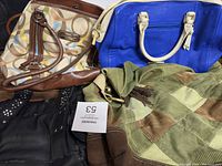 Lot of four purses including a Coach logo beige patterned purse with brown leather, a blue leather handbag, a green and brown patchwork handbag, and a black studded bag.