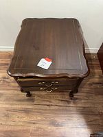 Full top view of the wooden night table showing carved edge and surface wear.