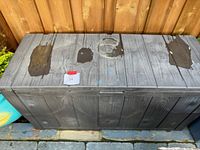 Top-down view showing three large worn patches on the lid and overall weathering.