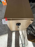 Front view of the beige metal safe with combination dial and lever handle, shows overall condition and size.