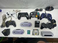 Top-down view of all controllers, memory cards, and accessories arranged on table.