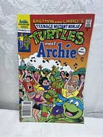 Front cover of the Teenage Mutant Ninja Turtles Adventures 1991 Spring comic showing colorful illustration of Turtles meeting Archie characters.
