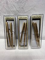 Three sets of Scripto Everglide pen and pencil sets in original clear plastic boxes, showing front view of the boxed sets with visible gold-tone pens and pencils.