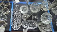 Overview of assorted cut glass and crystal serveware and decorative dishes with intricate cuts and patterns