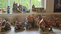 Frontal shot of multiple David Winter ceramic cottages on a windowsill