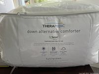 Photo of packaging label showing brand Therapedic, Tencel fabric, features like temperature regulation, softness, plush fiber loft, and down alternative filling for full/queen size comforter.
