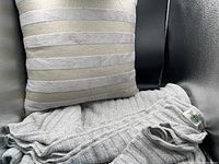 View of the Cottage Cove throw blanket and matching pillow arranged together, showing texture and color details