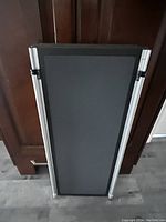 Top view of folded dog ramp showing black non-slip surface and aluminum edges.