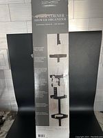 Photo of product box showing full shower caddy with four shelves and tension rod expanding from 91-103 inches